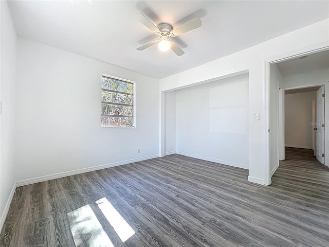 unfurnished bedroom featuring a closet, baseboards, wood finished floors, and a ceiling fan