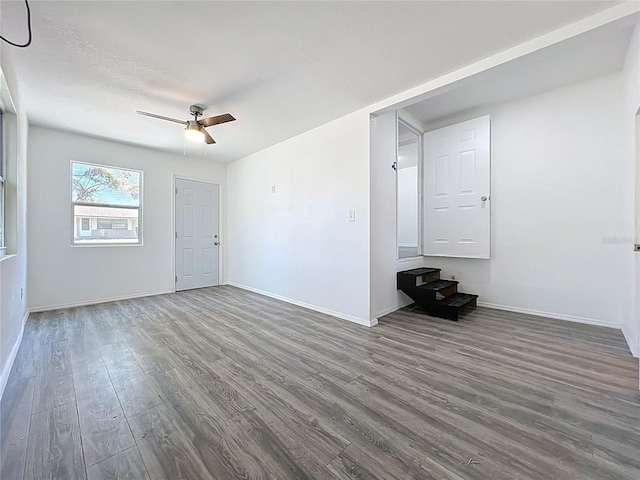 unfurnished living room with baseboards, a ceiling fan, and wood finished floors