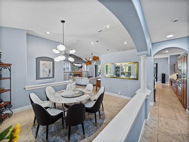 dining room with baseboards, decorative columns, arched walkways, and vaulted ceiling