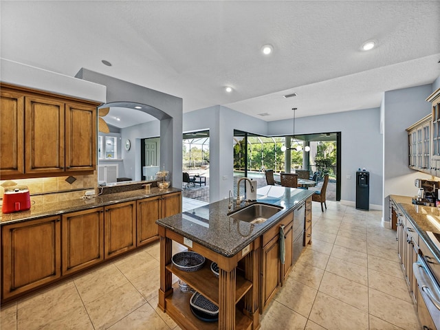 kitchen featuring light tile patterned floors, a sink, brown cabinetry, and open shelves