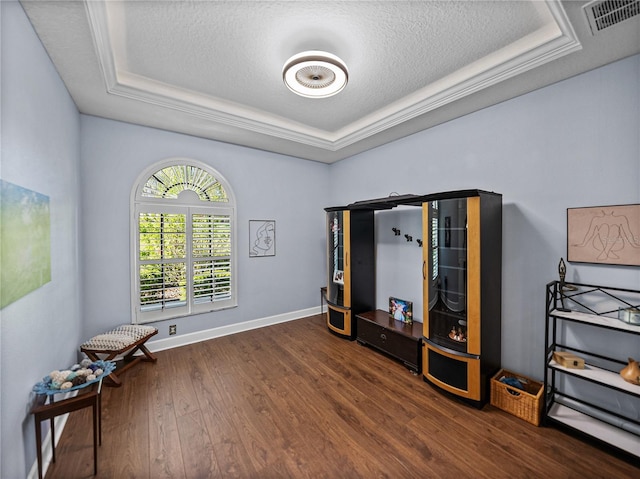 misc room with a tray ceiling, a textured ceiling, and wood finished floors