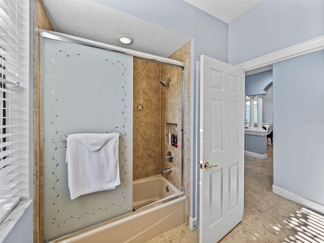 bathroom featuring baseboards, enclosed tub / shower combo, tile patterned floors, and a textured ceiling