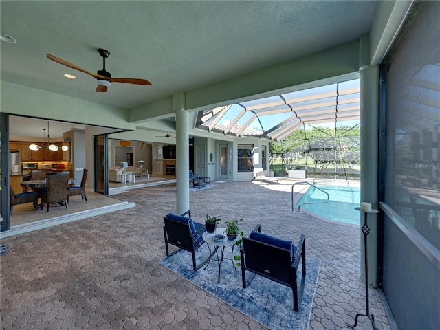 view of patio with a ceiling fan, an outdoor pool, and a lanai