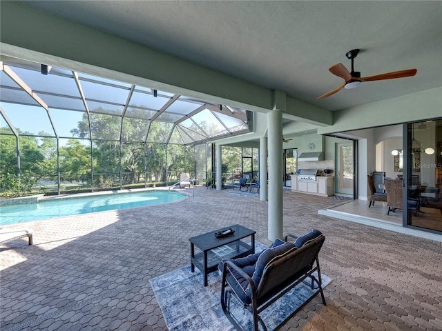 outdoor pool featuring exterior kitchen, a lanai, ceiling fan, and a patio area