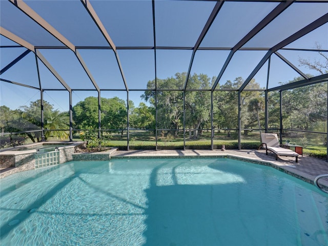 view of swimming pool with glass enclosure, a patio, and a pool with connected hot tub