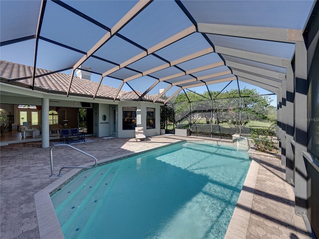 outdoor pool with a patio and glass enclosure