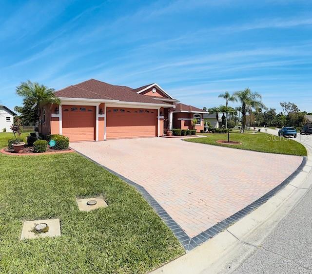 single story home with driveway, an attached garage, and a front lawn