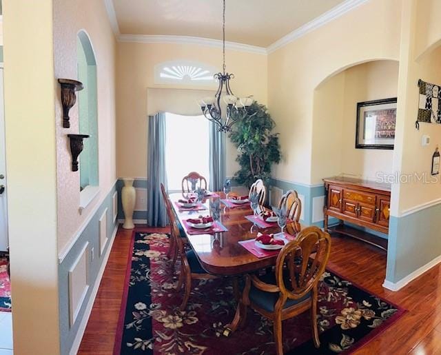 dining space with visible vents, arched walkways, dark wood-type flooring, crown molding, and a notable chandelier