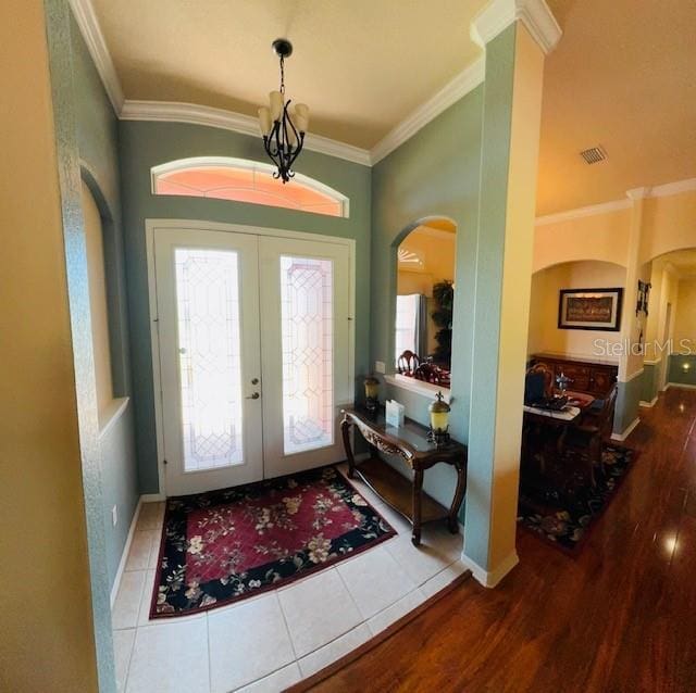 entryway featuring visible vents, arched walkways, and ornamental molding