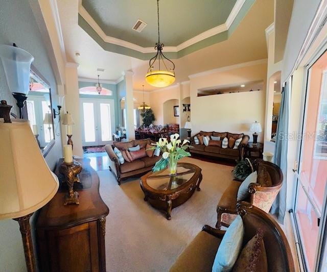 living room featuring a tray ceiling, visible vents, carpet flooring, and french doors