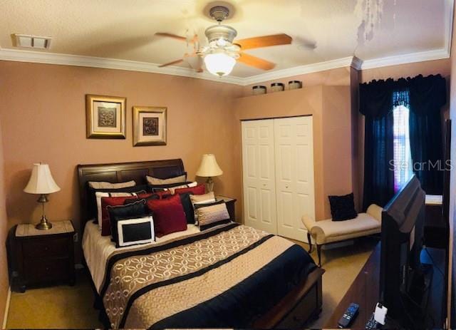 carpeted bedroom with visible vents, a closet, ornamental molding, and a ceiling fan