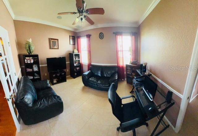 living room with crown molding and ceiling fan