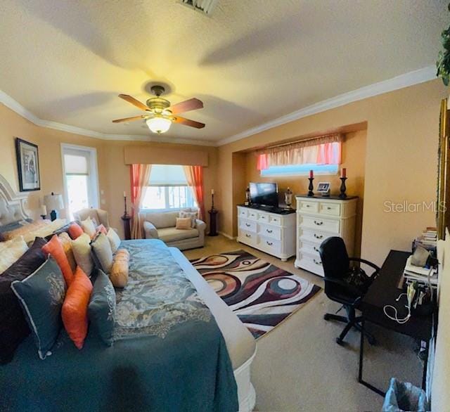 bedroom featuring a textured ceiling, crown molding, visible vents, and light carpet