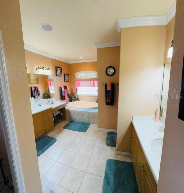 full bath with tile patterned flooring, two vanities, a garden tub, and ornamental molding