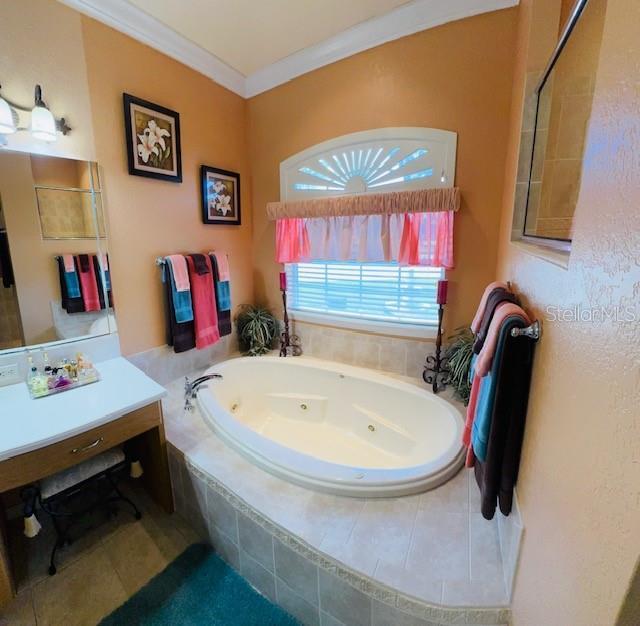 bathroom with vanity, a whirlpool tub, and ornamental molding