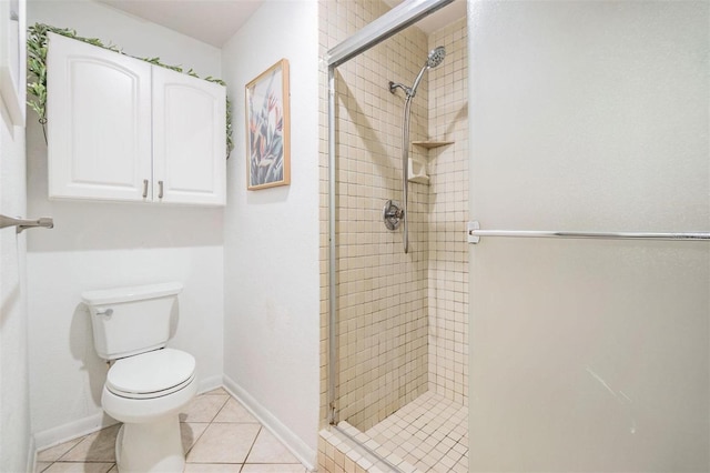 bathroom featuring tile patterned floors, baseboards, toilet, and a shower stall