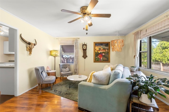 living room with baseboards, a ceiling fan, and wood finished floors