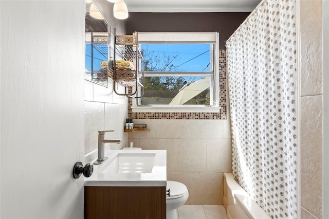 bathroom with vanity, tile patterned flooring, shower / tub combo, tile walls, and toilet