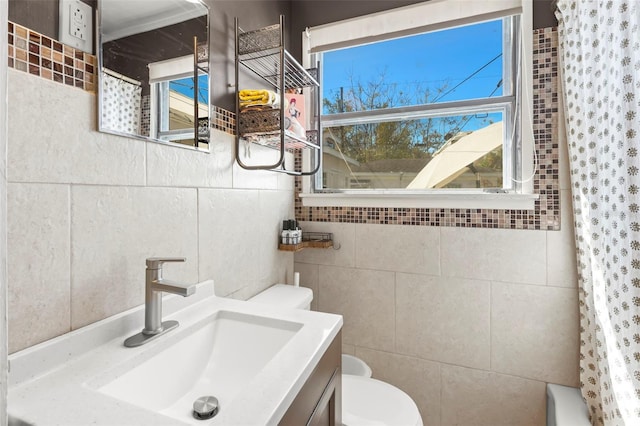 bathroom with tile walls, toilet, vanity, and shower / bathtub combination with curtain