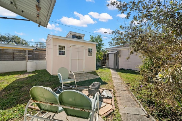 view of yard with an outbuilding, fence, and a shed