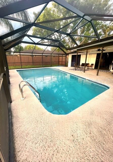 view of pool with a lanai, a fenced in pool, a patio, and fence