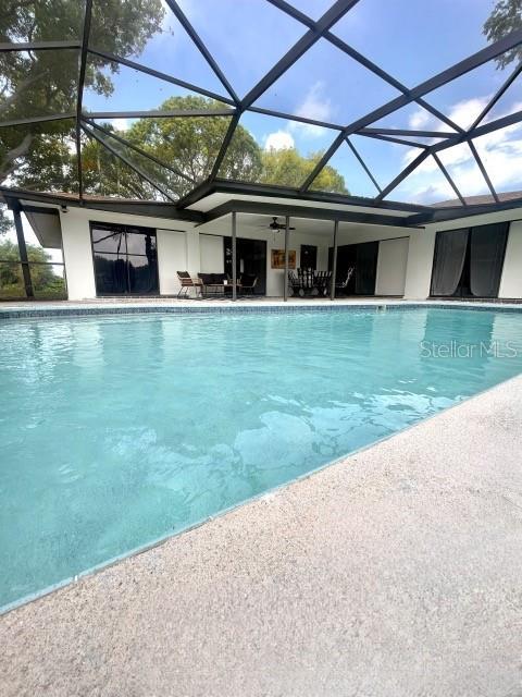 outdoor pool featuring a lanai and a patio area