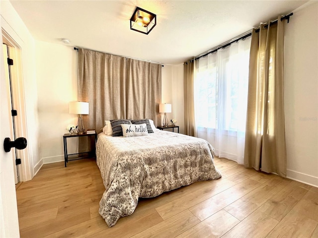 bedroom with baseboards and light wood-type flooring