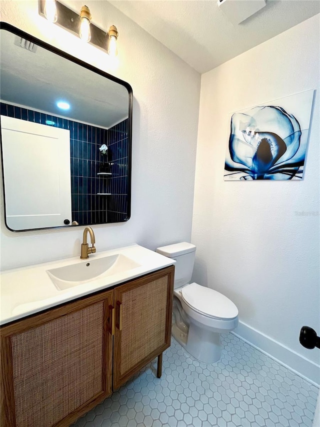 bathroom featuring baseboards, toilet, vanity, and tile patterned flooring