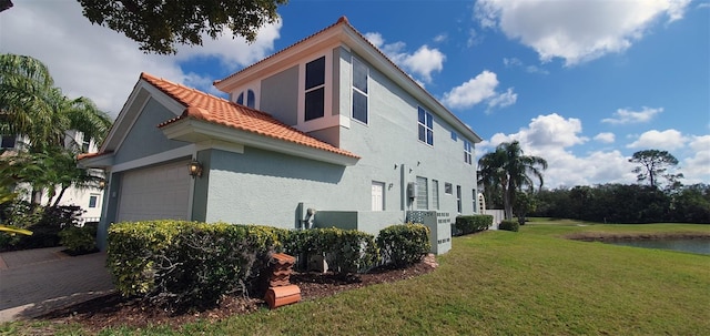 7279 Maidencane Ct, Seminole, FL 33777 - view of side of home featuring a yard, an attached garage, stucco siding, and a tile roof