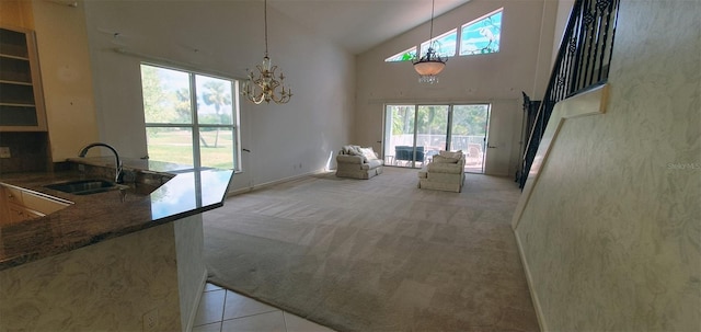 7279 Maidencane Ct, Seminole, FL 33777 - living area with high vaulted ceiling, light tile patterned floors, light colored carpet, and a chandelier