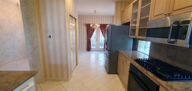 7279 Maidencane Ct, Seminole, FL 33777 - kitchen featuring stone counters, wallpapered walls, an inviting chandelier, black appliances, and glass insert cabinets