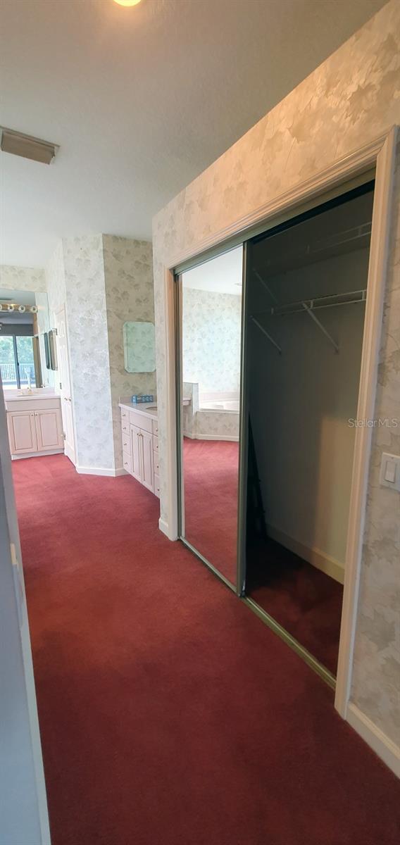 7279 Maidencane Ct, Seminole, FL 33777 - corridor with dark colored carpet, baseboards, and wallpapered walls