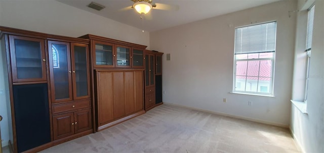 7279 Maidencane Ct, Seminole, FL 33777 - interior space with baseboards, light colored carpet, visible vents, and ceiling fan