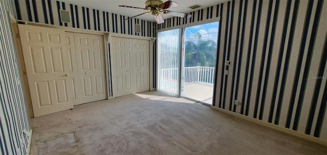 7279 Maidencane Ct, Seminole, FL 33777 - unfurnished bedroom with visible vents, carpet floors, wallpapered walls, access to exterior, and two closets