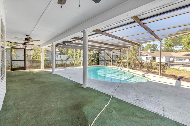 pool featuring glass enclosure, a patio area, and ceiling fan