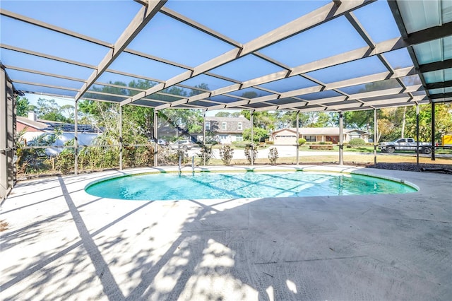 outdoor pool with glass enclosure and a patio