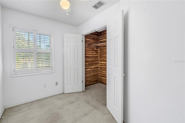 unfurnished bedroom with visible vents, a closet, a walk in closet, and carpet flooring