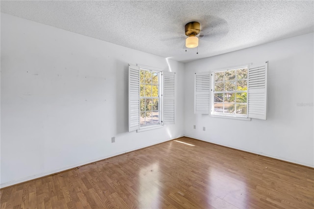 spare room with plenty of natural light, wood finished floors, and a textured ceiling