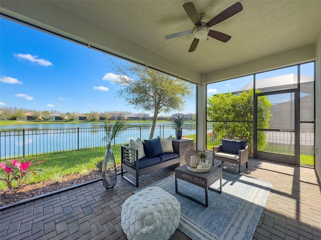 sunroom with a water view and ceiling fan