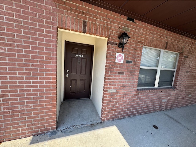 view of exterior entry with brick siding