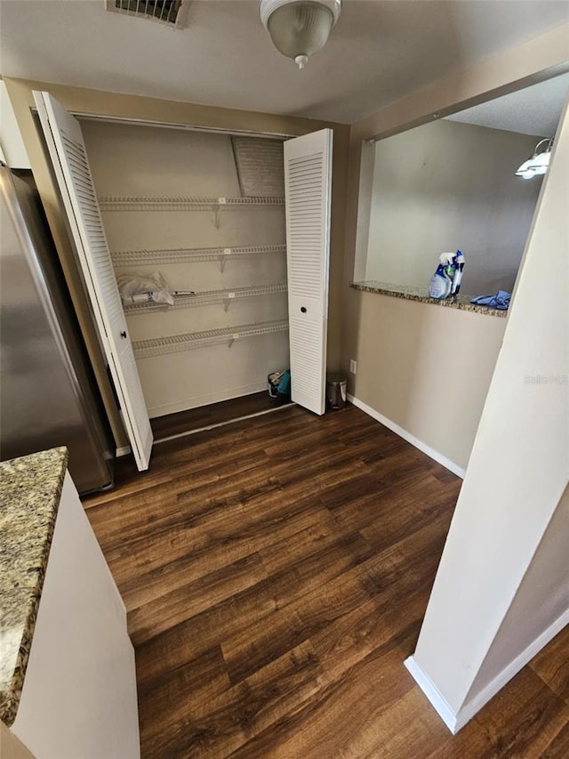 laundry room with laundry area, visible vents, dark wood-type flooring, and baseboards