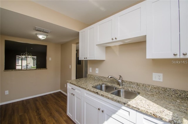 kitchen featuring a sink, visible vents, dark wood-style floors, and white cabinets