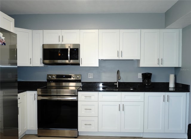 kitchen featuring a sink, appliances with stainless steel finishes, and white cabinetry