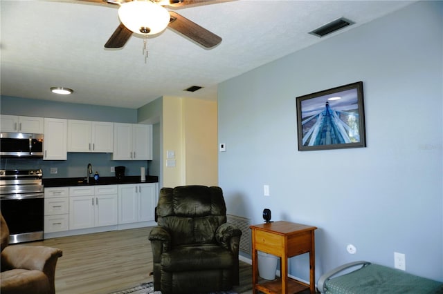 interior space featuring white cabinetry, visible vents, appliances with stainless steel finishes, and a sink