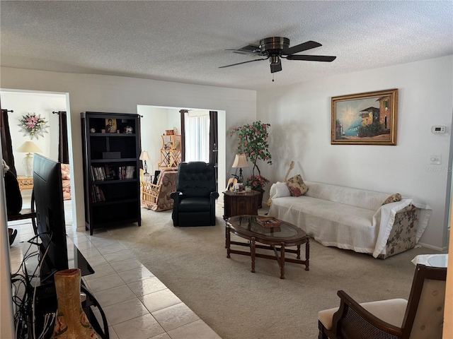 living room with light colored carpet, light tile patterned flooring, a ceiling fan, and a textured ceiling