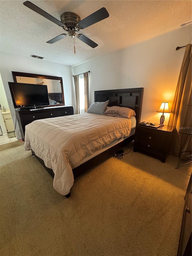 bedroom with visible vents, a textured ceiling, ceiling fan, and carpet flooring