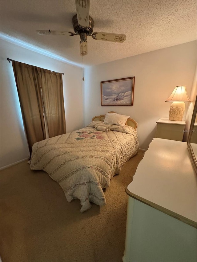 bedroom with a ceiling fan, carpet floors, and a textured ceiling