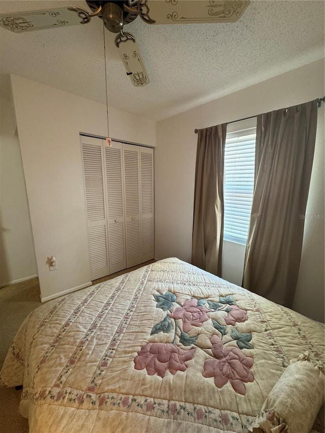 carpeted bedroom featuring a closet, baseboards, and a textured ceiling