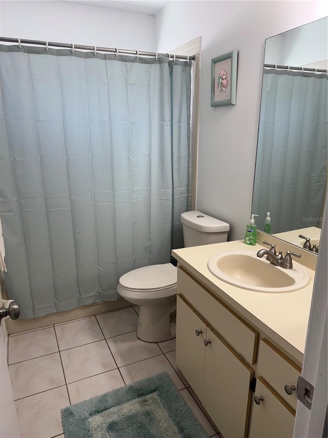 bathroom featuring tile patterned flooring, toilet, vanity, and a shower with curtain