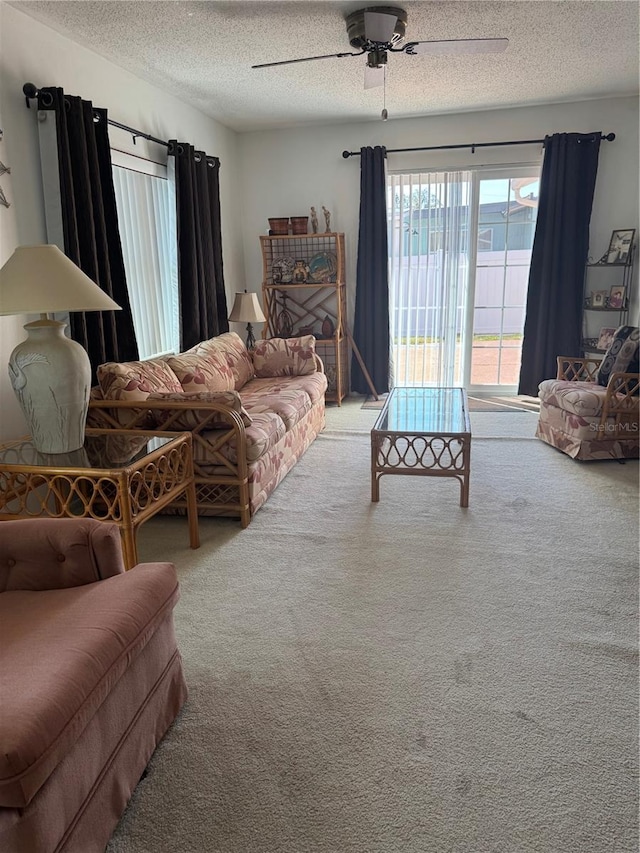 living room with carpet floors, a textured ceiling, and a ceiling fan